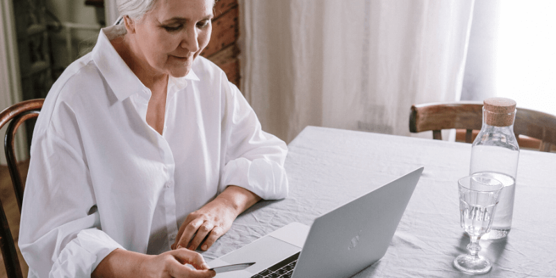 elderly woman on laptop in assessment conversation with clinician